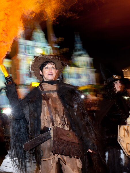 Eine Person in traditioneller Perchtenkleidung hält eine Fackel beim Krampuslauf in Graz. | © Graz Tourismus - Harry Schiffer