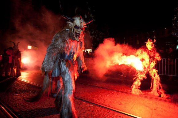 Krampus and Perchten figures in darkness, surrounded by smoke. | © Graz Tourismus - Harry Schiffer