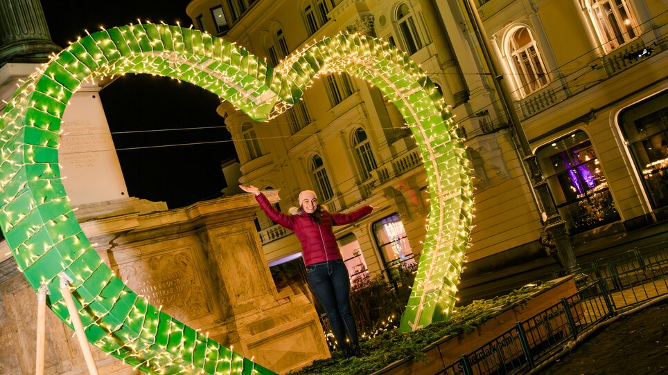 Eine Person posiert in einem beleuchteten Herz in Graz. | © Mias Photoart