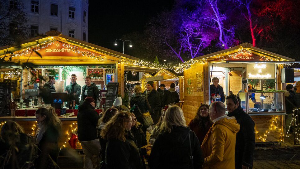 Beleuchtete Stände auf dem Adventmarkt am Eisernen Tor in Graz, viele Menschen tummeln sich und genießen die festliche Atmosphäre. | © Peter Hutter