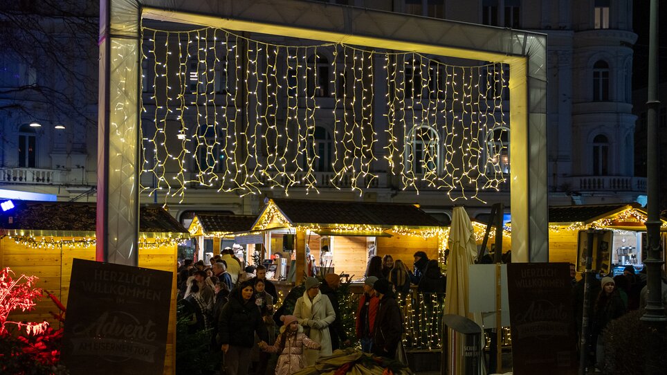 Weihnachtsmarkt am Eisernen Tor in Graz mit Lichtern und Menschen. | © Peter Hutter