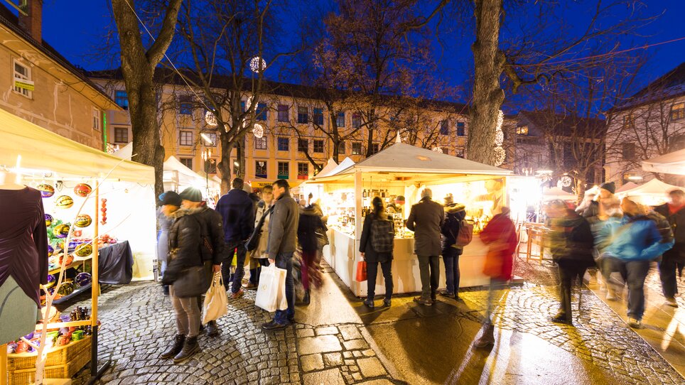Advent in Graz I Handicraft market on Färberplatz square | © Graz Tourismus - Harry Schiffer Busy handicraft market in Graz at night with stalls and visitors. | © Graz Tourismus - Harry Schiffer