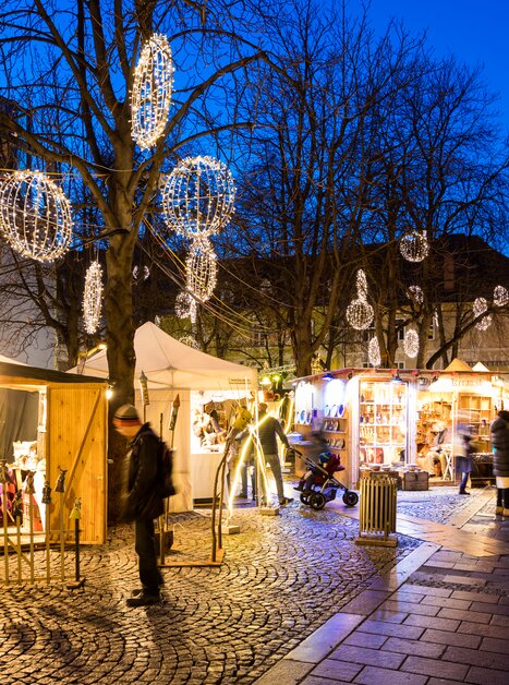 Weihnachtsmarkt mit Ständen, Lichtern und Besuchern in Graz. | © Graz Tourismus - Harry Schiffer