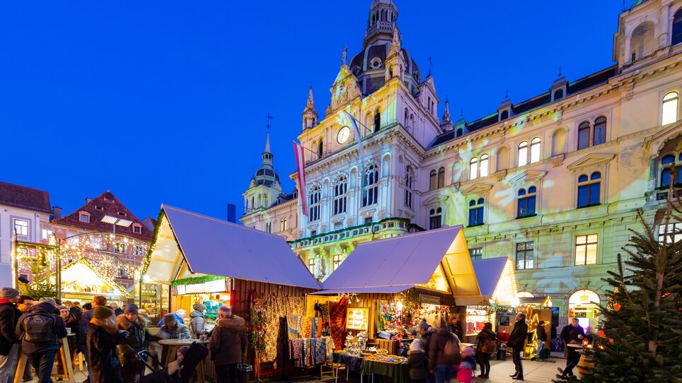 Weihnachtsmarkt in Graz mit festlich dekorierten Ständen und der Grazer Rathaus im Hintergrund. | © Graz Tourismus - Harry Schiffer