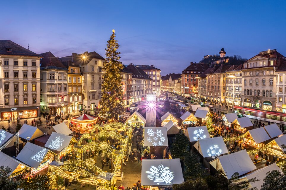 Christmas market in Graz with festive stalls and a large illuminated tree. | © Graz Tourismus - Rene Walter 