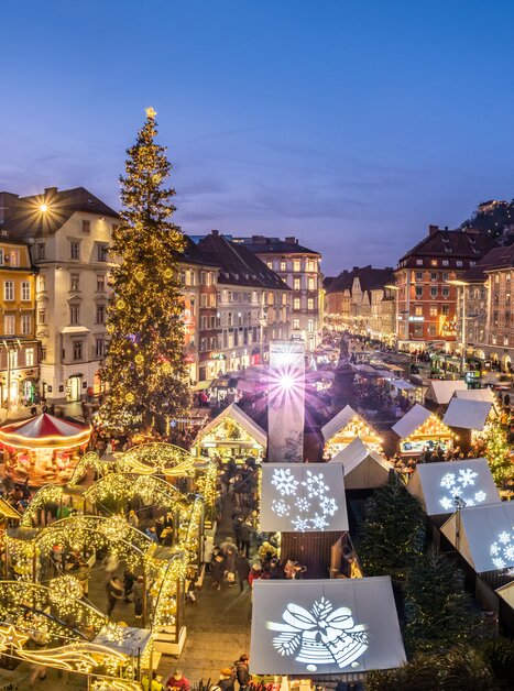 Weihnachtsmarkt in Graz mit festlich beleuchteten Ständen und großer Tanne. | © Graz Tourismus - Rene Walter 
