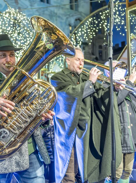 I musicisti suonano al mercatino di Natale a Graz. Un tubista è visibile in primo piano. | © Stadt Graz - Foto Fischer