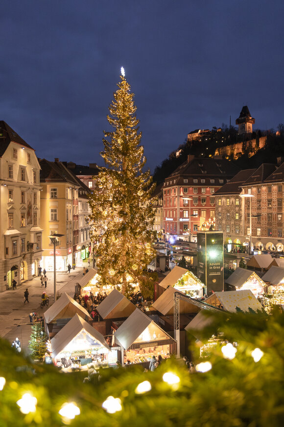 Mercatino di Natale a Graz con albero decorato e illuminazione festosa. | © Vincent Croce
