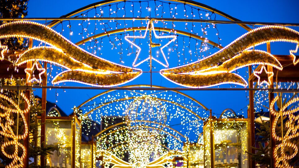 Illuminated Christmas market with stars and lights under the evening sky. | © Graz Tourismus - Harry Schiffer