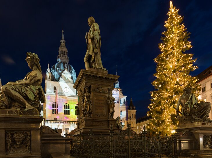 Albero di Natale e statue in Hauptplatz a Graz di notte. | © Graz Tourismus - Harry Schiffer