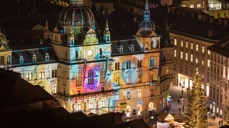 Beleuchtetes Rathaus in Graz beim Christkindlmarkt mit bunten Lichtern und Dekoration. | © Graz Tourismus - Harry Schiffer