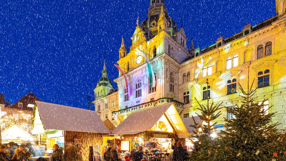 Christmas market with festive stalls and snow, Graz Town Hall in the background. | © Graz Tourismus - Harry Schiffer