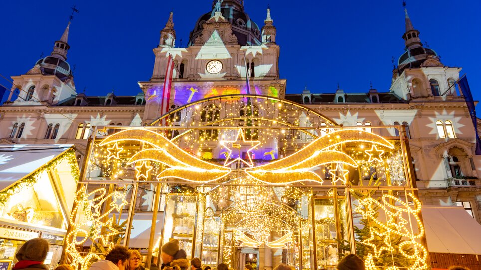 Illuminated Christmas market at Graz Hauptplatz with the city hall in the background. | © Graz Tourismus - Harry Schiffer