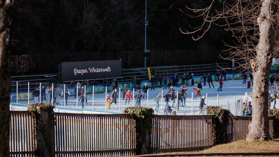 People ice skating at Graz Winter World ice rink, surrounded by winter scenery. | © Daniel Kindler