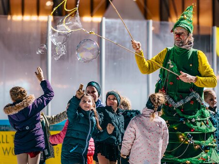 Children ice skating around a Christmas-themed character. | © Kuro Simon