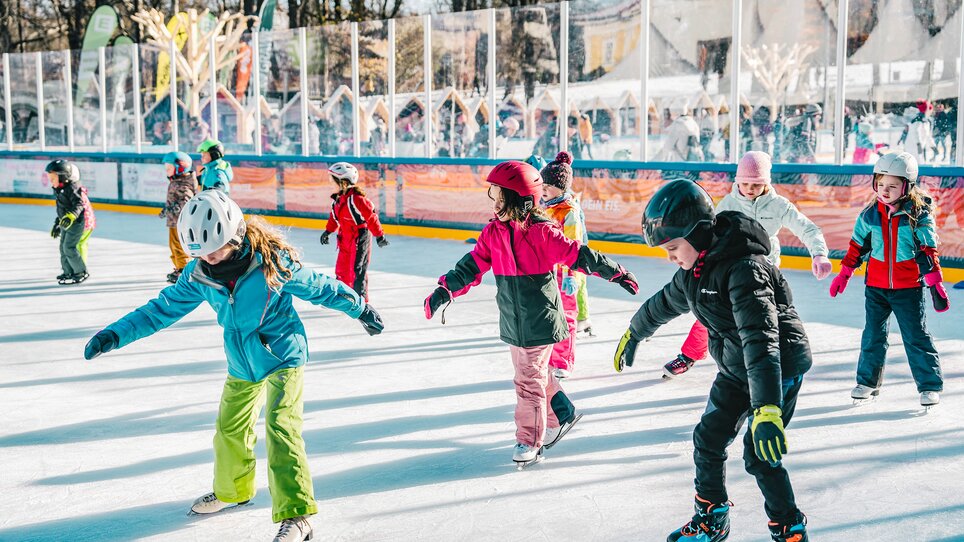 Children skating on a festively decorated ice rink. | © Luke Goodlife