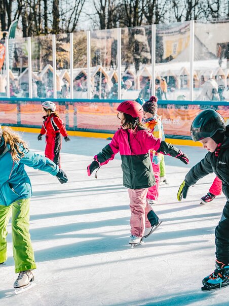 Children skating on a festively decorated ice rink. | © Luke Goodlife