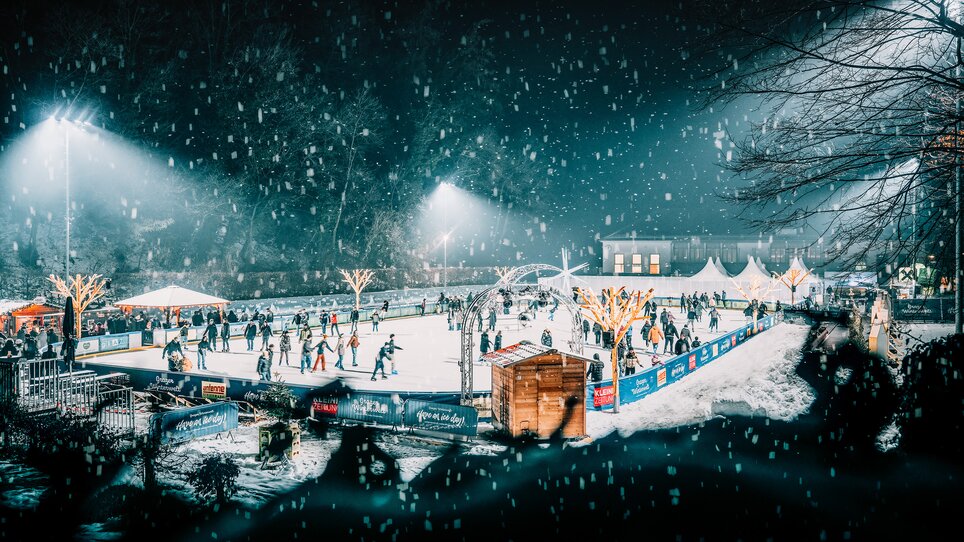 Winter scene at the ice skating rink in Graz, featuring numerous skaters and festive lights. | © Stefan Leitner