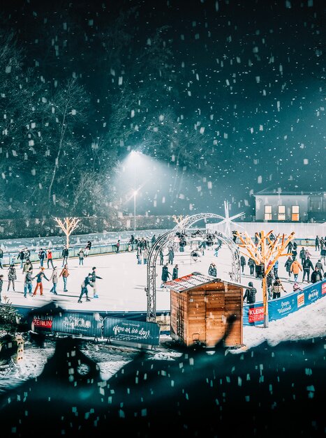Winter scene at the ice skating rink in Graz, featuring numerous skaters and festive lights. | © Stefan Leitner