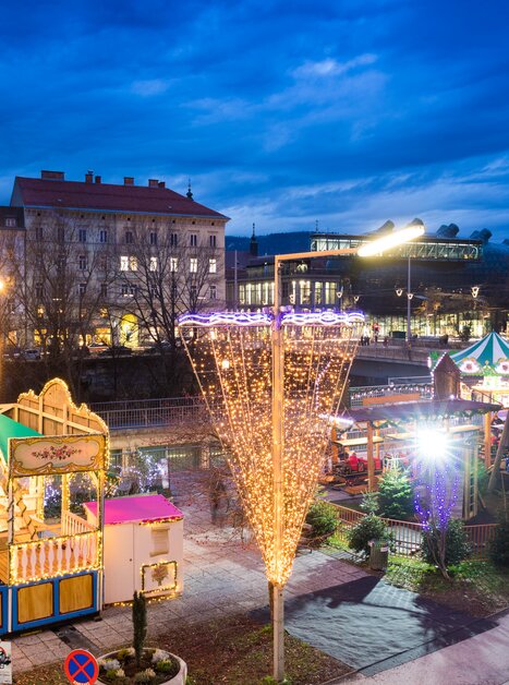 Illuminated rides and stalls at the Advent market in Graz. | © Graz Tourismus-Harry Schiffer