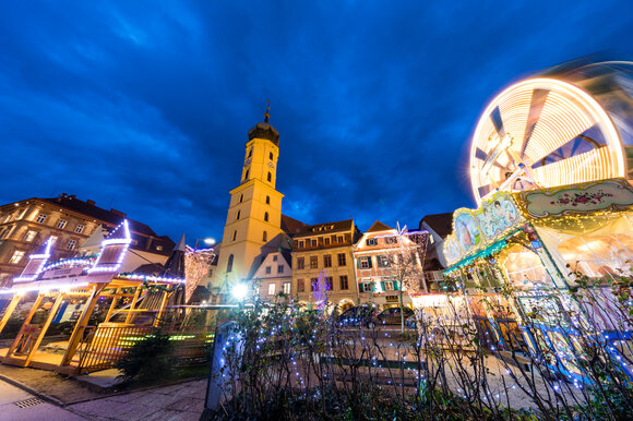 Città illuminata con torre e giostre durante il periodo avventizio. | © Graz Tourismus-Harry Schiffer