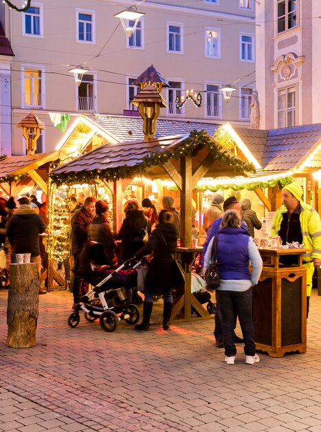 Busy scene at the Christmas market in Graz with festively decorated wooden stalls and visitors. | © Graz Tourismus - Harry Schiffer