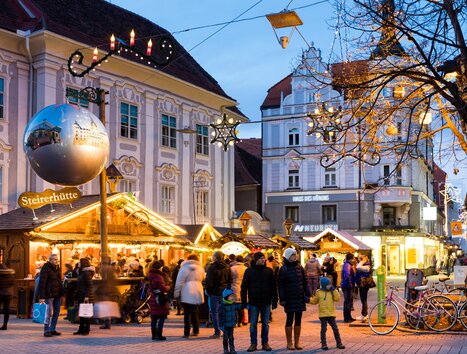 View of the Christmas market at Südtiroler Platz in Graz, featuring festive lights and many visitors. | © Graz Tourismus - Harry Schiffer