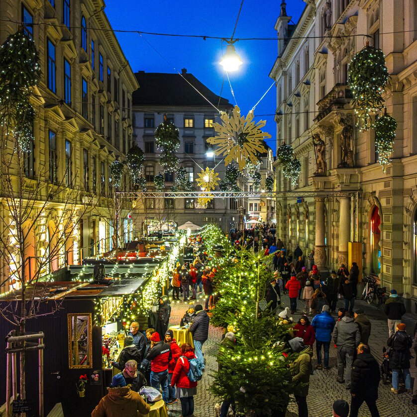 Avvento a Graz I Adventlounge Schmiedgasse | © Rene Walter Bancarelle di avvento illuminate e mercatino di Natale nella Schmiedgasse, Graz, serata festiva con molti visitatori. | © Rene Walter