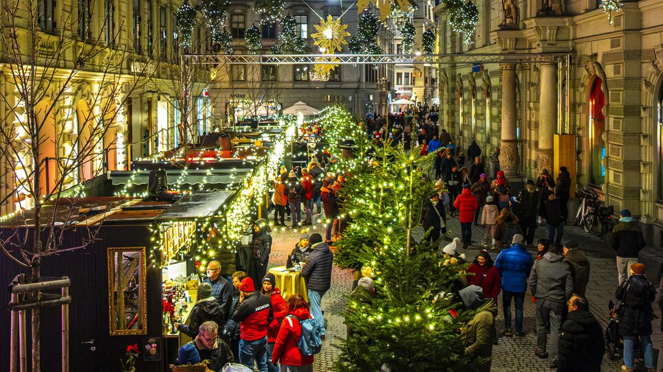 Beleuchtete Adventstände und Weihnachtsmarkt in der Schmiedgasse, Graz, festlicher Abend mit vielen Besuchern. | © Rene Walter