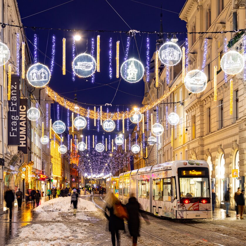 Beleuchtete Herrengasse in Graz mit Tram und Weihnachtsdekoration. | © Graz Tourismus - Harry Schiffer