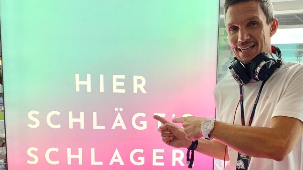 A man with headphones points to a Radio Flamingo sign. | © Radio Flamingo