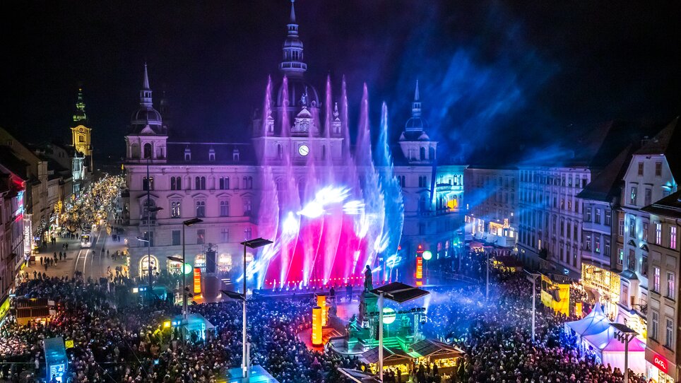 Blick auf den Hauptplatz in Graz mit festlicher Beleuchtung und Wasserfontänen. | © Ivents-Kulturagentur - Erwin Scheriau