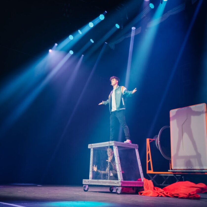 Magische Darbietung auf der Bühne | © Fab Fox Ein Performer steht auf einer Kiste während einer Illusionsshow. | © Fab Fox