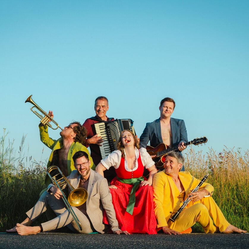 six musicians in colourful dresses are posing with their instruments | © Astrid Bartl
