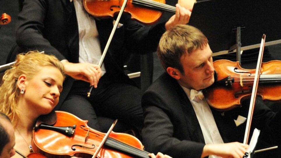 Geiger spielen im Orchester, musikalische Atmosphäre.