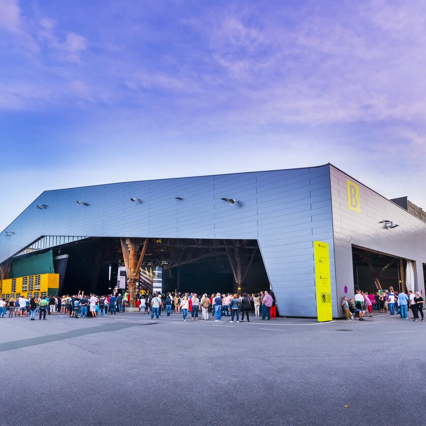 Menschen warten vor der Freiluftarena B im Messegelände Graz auf den Beginn des Konzerts | © MCG - Werner Krug