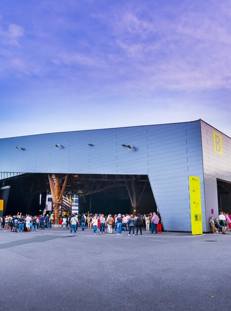 Menschen warten vor der Freiluftarena B im Messegelände Graz auf den Beginn des Konzerts | © MCG - Werner Krug