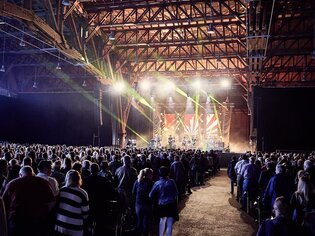 Ein begeistertes Publikum genießt ein Konzert in einer großen Halle mit beeindruckender Beleuchtung. | © Rene Langer Photography