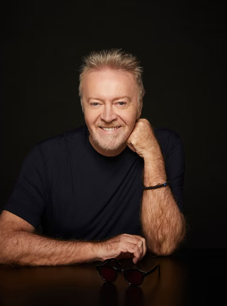 il cantattore Umberto Tozzi siedi a una tavola indossando un T-Shirt nero | © Umberto Tozzi