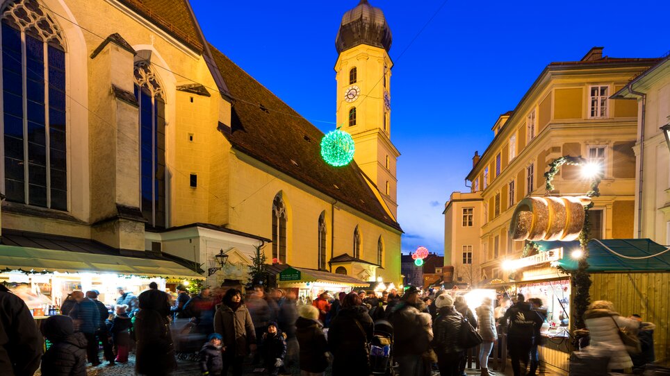 Bustling scene of the Christmas market in the Franziskanerviertel at night with festively lit stalls. | © Graz Tourismus - Harry Schiffer
