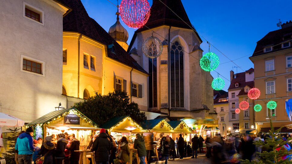 Christmas market in Franziskanerviertel, festively lit with stalls and people. | © Graz Tourismus - Harry Schiffer