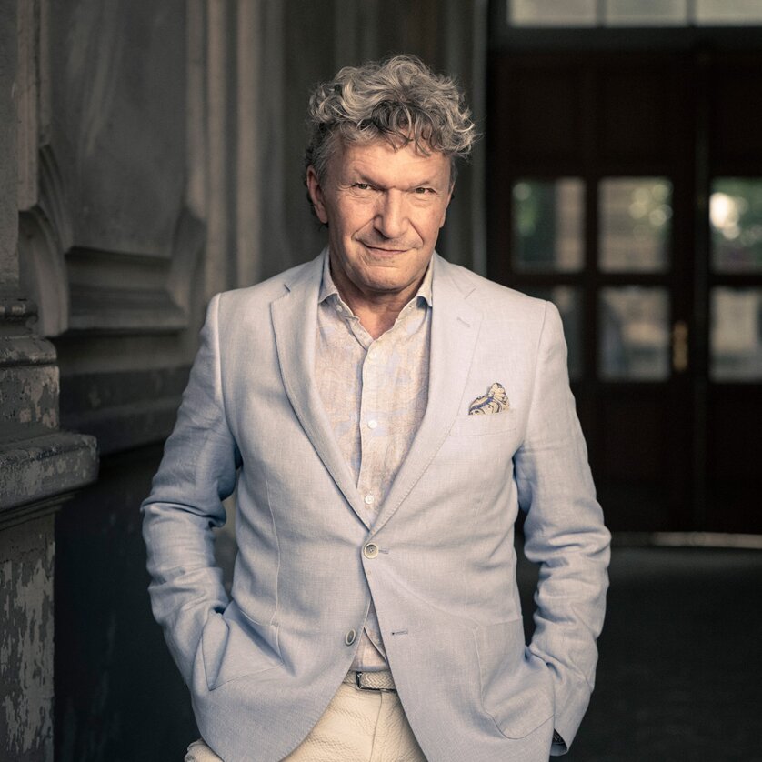 Markus Schirmer poses in a suit and shirt with a relaxed smile. | © Christian Jungwirth