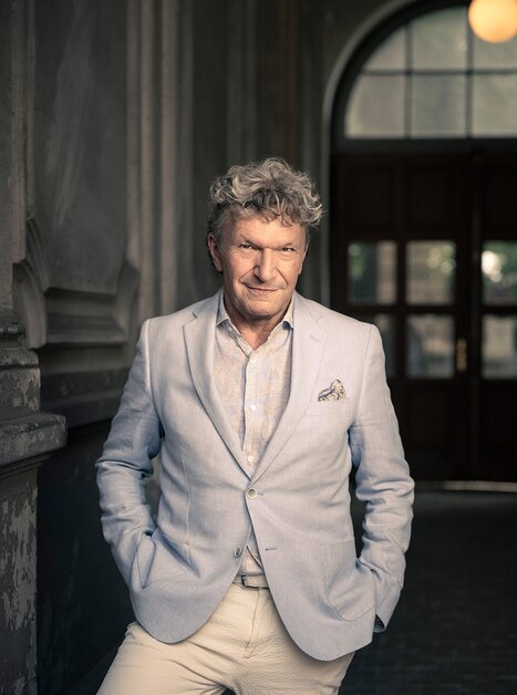 Markus Schirmer posa in abito e camicia con un sorriso rilassato. | © Christian Jungwirth