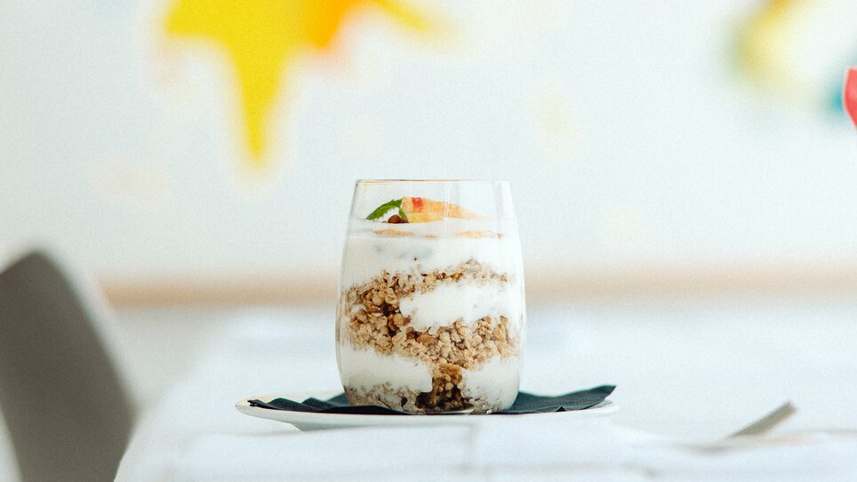 A glass filled with yoghurt, granola and fresh fruit | © Augartenhotel x einsnullneun