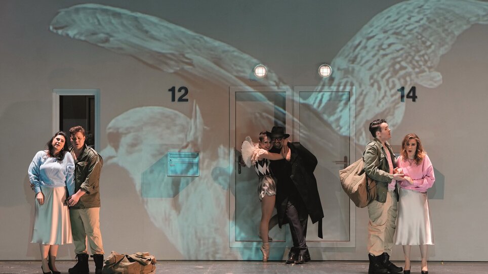 Actors in a theater performance, with a projection in the background. | © Reinhard Winkler