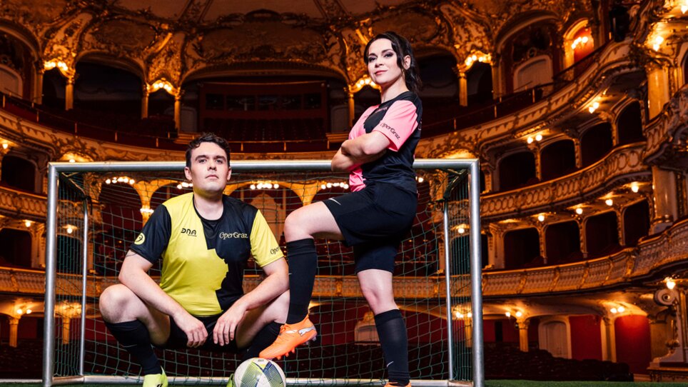 Due artisti in maglia da calcio posano in uno splendido teatro con una porta da calcio. | © Ingo Pertramer - Oper Graz