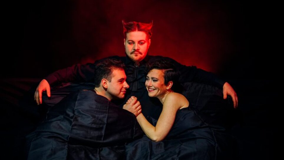 Tre persone in coperte nere con illuminazione drammatica. | © Ingo Pertramer