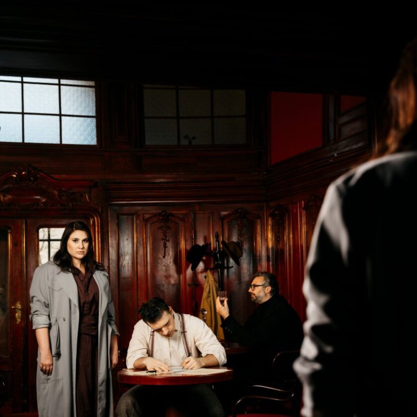 Three people in an elegant room, a woman watches a man writing. | © Ingo Petramer- Oper Graz