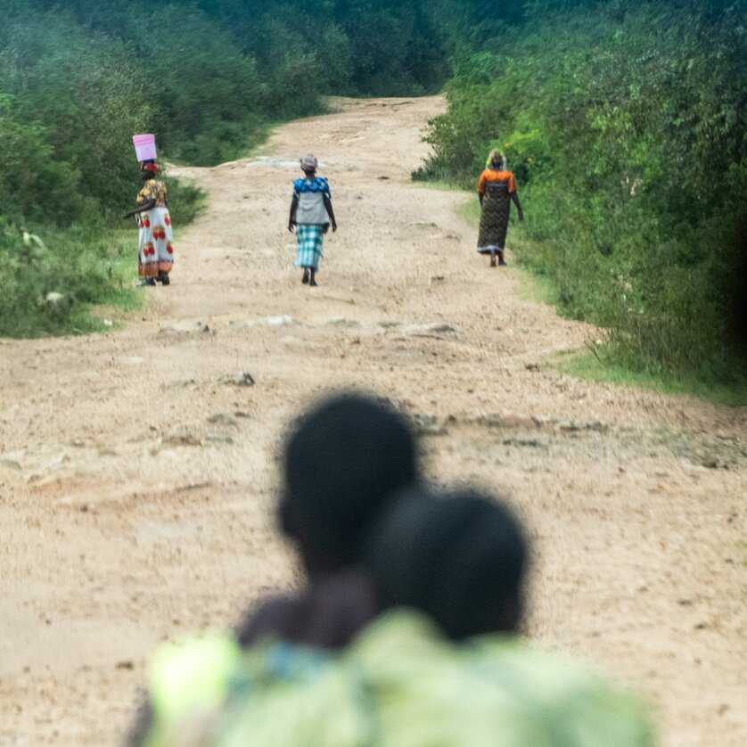 Drei Frauen gehen einen unbefestigten Weg entlang in der Natur. | © Caterina Richter