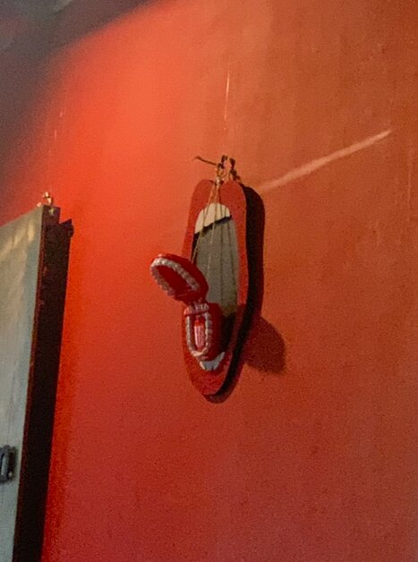 Ein kreatives Kunstwerk in Form eines Mundes an einer roten Wand. | © Lena Pöltl